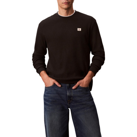 Pull noir uni texturé avec un petit patch brodé...