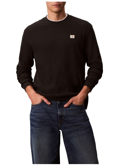 Pull noir uni texturé avec un petit patch brodé et à col rond