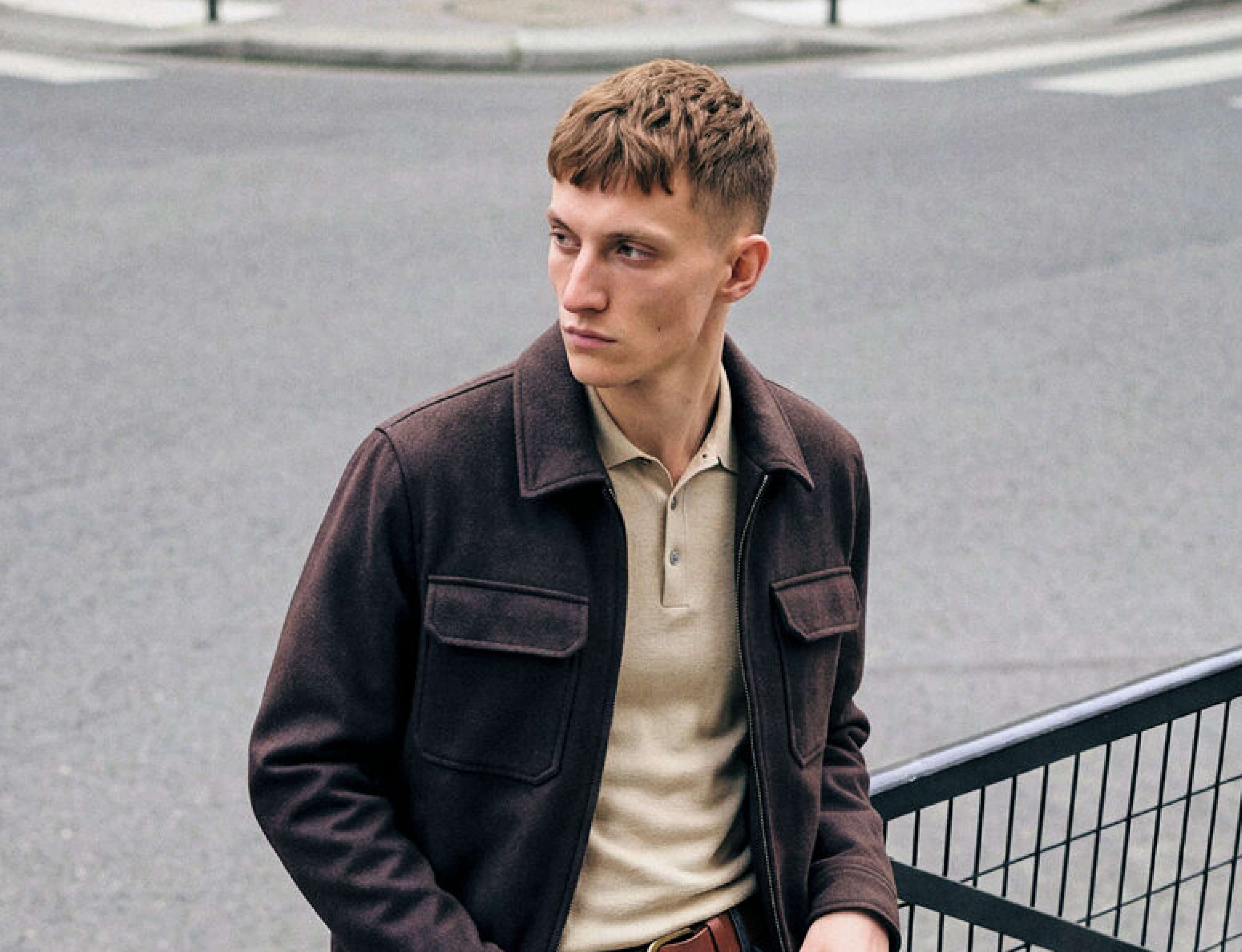 Homme portant une veste en jean et un débardeur blanc Jack & Jones, look urbain avec casquette bleue